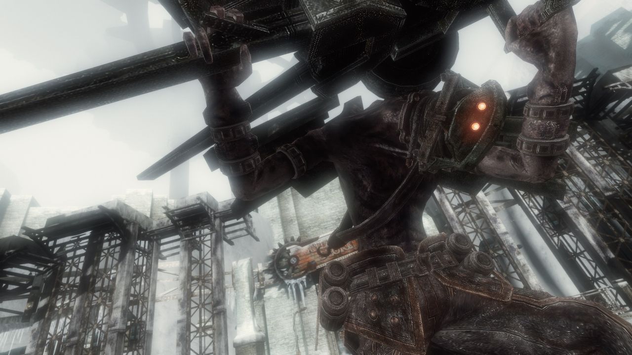 Official screenshot: a close-up of an armoured figure holding a heavy weapon against an industrial backdrop
